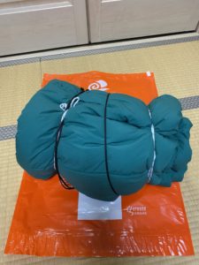 紐で寝袋を締めこむ