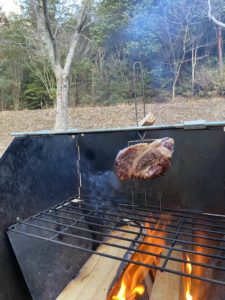 焚火で肉を焼く