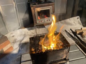 薪ストーブの前で炭火焼き