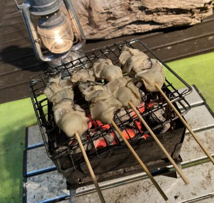炭火で焼く牡蠣の串焼き
