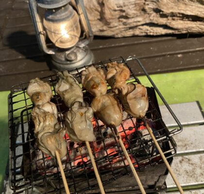 炭火で焼く牡蠣の串焼き